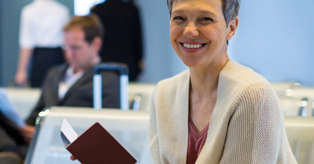 Una persona sonriente sosteniendo su pasaporte tras haber obtenido con éxito la nacionalidad española por residencia en España